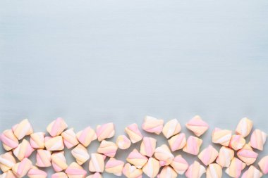 Marshmallow boşaltmak mavi zemin üzerine. Düz yatıyordu veya üst 