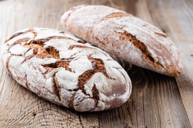 Ahşap arka planda altın kırsal ekmek ve çörekler