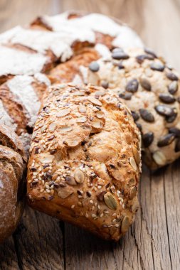 Ahşap arka planda altın kırsal ekmek ve çörekler