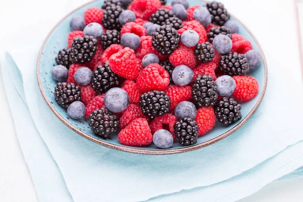 Fresh raspberries in a plate on a  vintage background. — Stock Photo, Image