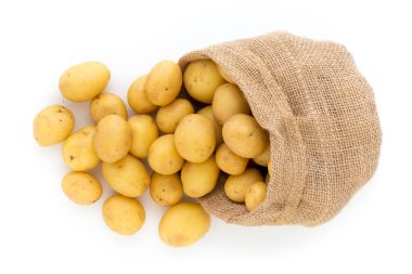 Ahşap arka planda taze çiğ patates çuvalı.