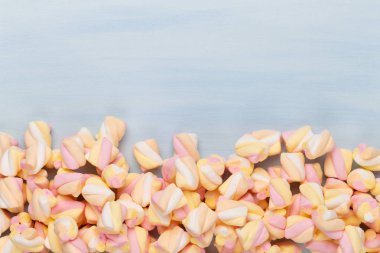 Marshmallow boşaltmak mavi zemin üzerine. Düz yatıyordu veya üst 