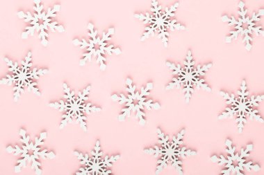 Noel arkaplanı. Beyaz kar süslemeleri pembe bir sırtüstü