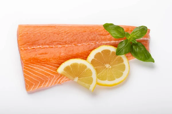 Fresh raw salmon fillets with herbs and lemon isolated on white — Stock Photo, Image