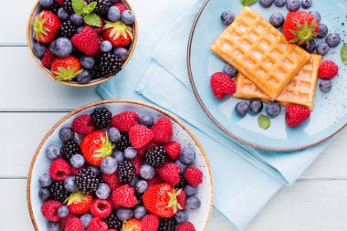 Ahşap arka planda bir tabakta taze meyve salatası. Düz konum, üst görünüm, kopyalama alanı.