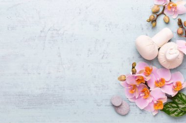 Spa aromaterapi arka planı, basit orkide çiçekleriyle süslenmiş çeşitli güzellik ürünleri..