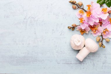 Spa aromaterapi arka planı, basit orkide çiçekleriyle süslenmiş çeşitli güzellik ürünleri..