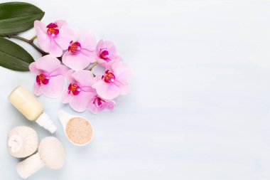 Spa aromaterapi arka planı, basit orkide çiçekleriyle süslenmiş çeşitli güzellik ürünleri..