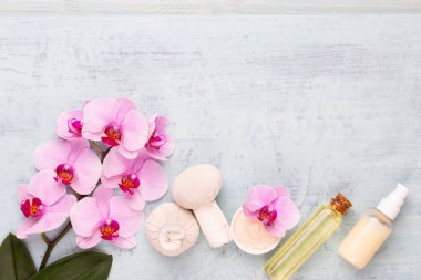 Spa aromaterapi arka planı, basit orkide çiçekleriyle süslenmiş çeşitli güzellik ürünleri..