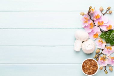 Spa aromaterapi arka planı, basit orkide çiçekleriyle süslenmiş çeşitli güzellik ürünleri..