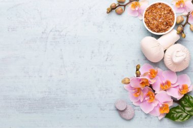 Spa aromaterapi arka planı, basit orkide çiçekleriyle süslenmiş çeşitli güzellik ürünleri..