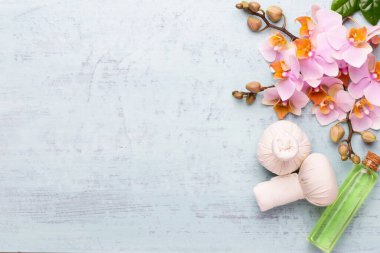 Spa aromaterapi arka planı, basit orkide çiçekleriyle süslenmiş çeşitli güzellik ürünleri..