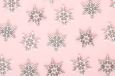 Noel arkaplanı. Pembe arka planda beyaz kar dekorasyonları.