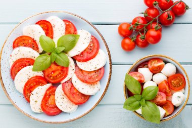 Domates, mozzarella peyniri, fesleğen ve baharatlar gri tahtada. İtalyan geleneksel Caprese salata malzemeleri. Akdeniz yemekleri.