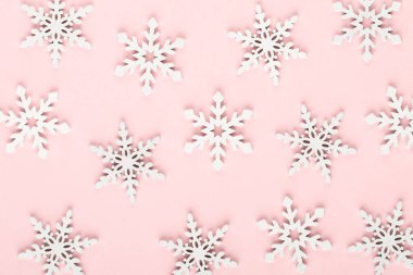 Noel arkaplanı. Pembe arka planda beyaz kar dekorasyonları.