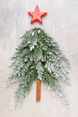 Noel ağacı, gri arka planda yatıyordu. Yeni yıl konsepti. Uzayı kopyala Düz yatıyordu. Üst görünüm.