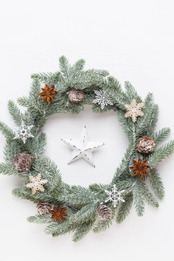 Noel tebrik kartı. Beyaz ahşap arka planda çelenk süsü. Yeni yıl konsepti. Uzayı kopyala Düz yatıyordu. Üst görünüm.