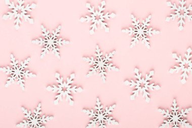 Noel arkaplanı. Pembe arka planda beyaz kar dekorasyonları.