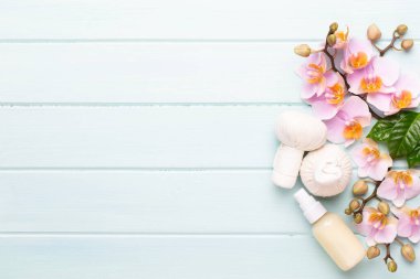 Spa aromaterapi arka planı, basit orkide çiçekleriyle süslenmiş çeşitli güzellik ürünleri..