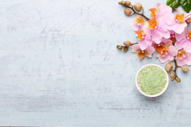 Spa aromaterapi arka planı, basit orkide çiçekleriyle süslenmiş çeşitli güzellik ürünleri..