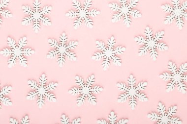 Noel arkaplanı. Pembe arka planda beyaz kar dekorasyonları.