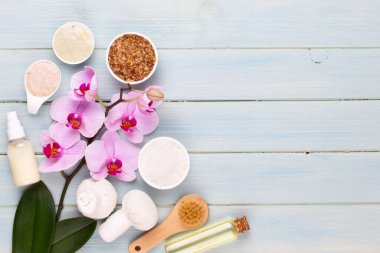 Spa aromaterapi arka planı, basit orkide çiçekleriyle süslenmiş çeşitli güzellik ürünleri..
