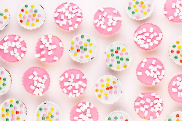 Beyaz arka planda çok renkli, güzel dekore edilmiş muffinler..