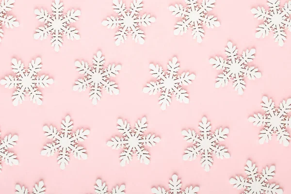 Noel arkaplanı. Pembe arka planda beyaz kar dekorasyonları.