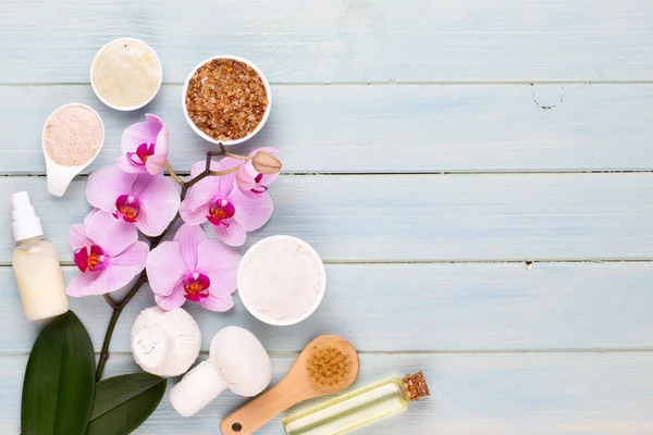 Spa aromaterapi arka planı, basit orkide çiçekleriyle süslenmiş çeşitli güzellik ürünleri..
