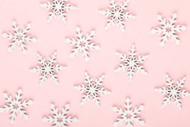 Noel arkaplanı. Pembe arka planda beyaz kar dekorasyonları.