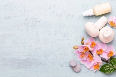 Spa aromaterapi arka planı, basit orkide çiçekleriyle süslenmiş çeşitli güzellik ürünleri..