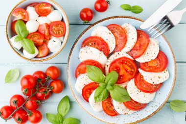 Domates, mozzarella peyniri, fesleğen ve baharatlar gri tahtada. İtalyan geleneksel Caprese salata malzemeleri. Akdeniz yemekleri.
