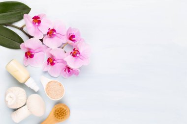 Spa aromaterapi arka planı, basit orkide çiçekleriyle süslenmiş çeşitli güzellik ürünleri..