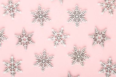 Noel arkaplanı. Pembe arka planda beyaz kar dekorasyonları.