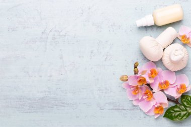 Spa aromaterapi arka planı, basit orkide çiçekleriyle süslenmiş çeşitli güzellik ürünleri..