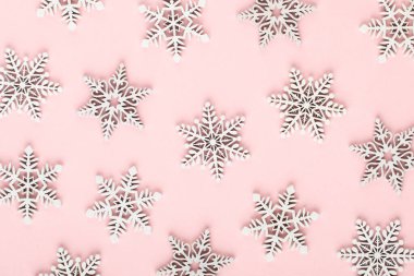Noel arkaplanı. Pembe arka planda beyaz kar dekorasyonları.
