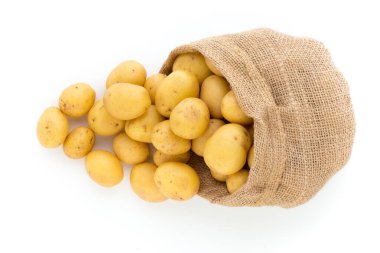 Ahşap arka planda taze çiğ patates çuvalı.