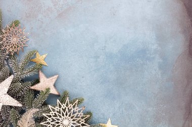 Noel kompozisyonu köknar ağacı dalları, mavi arka planda altın göğüs..