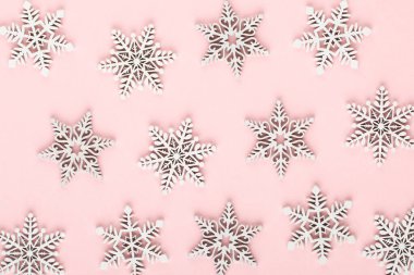 Noel arkaplanı. Pembe arka planda beyaz kar dekorasyonları.