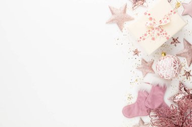 Noel minimalist ve pembe renkte basit bir kompozisyon. Noel yıldızı, beyaz arka planda süslemeler. Düz konum, kopyalama alanı olan üst görünüm
