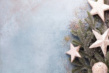Noel kompozisyonu köknar ağacı dalları, mavi arka planda altın göğüs..