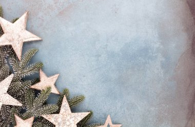 Noel kompozisyonu köknar ağacı dalları, mavi arka planda altın göğüs..