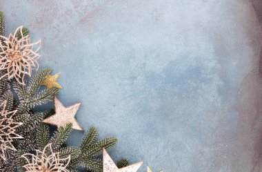 Noel kompozisyonu köknar ağacı dalları, mavi arka planda altın göğüs..