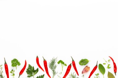 Baharatlı bitkisel yapraklar ve beyaz arka planda kırmızı biber. Sebze deseni. Çiçekler ve sebzeler beyaz arka planda. Üst manzara, düz uzanma.