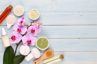Spa aromaterapi arka planı, basit orkide çiçekleriyle süslenmiş çeşitli güzellik ürünleri..