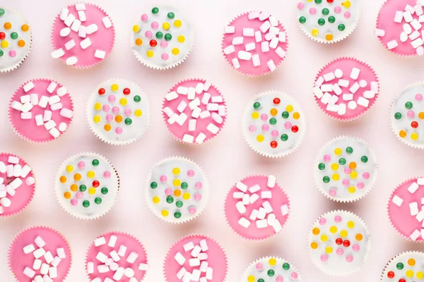 Beyaz arka planda çok renkli, güzel dekore edilmiş muffinler..