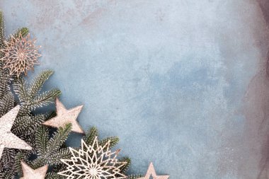Noel kompozisyonu köknar ağacı dalları, mavi arka planda altın göğüs..