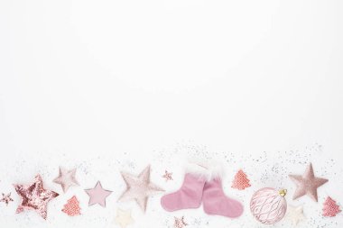 Noel minimalist ve pembe renkte basit bir kompozisyon. Noel yıldızı, beyaz arka planda süslemeler. Düz konum, kopyalama alanı olan üst görünüm