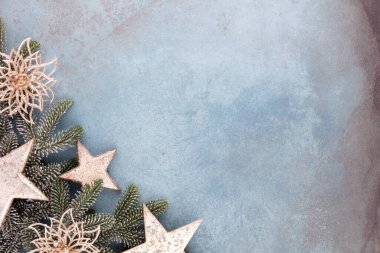Noel kompozisyonu köknar ağacı dalları, mavi arka planda altın göğüs..