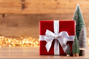 Kurdeleli Noel hediye kutuları ve bokeh arka planında ağaç..